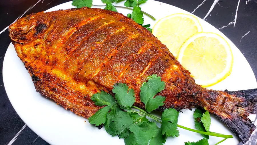 Whole pomfret fried golden with lemon and coriander
