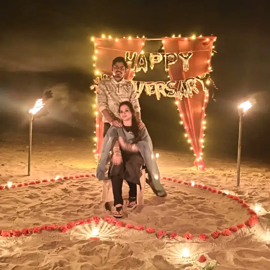 Couple posing under the happy anniversary lights