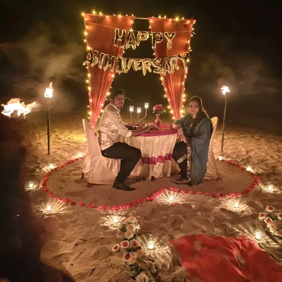 Couple at a candlelight anniversary dinner on the beach